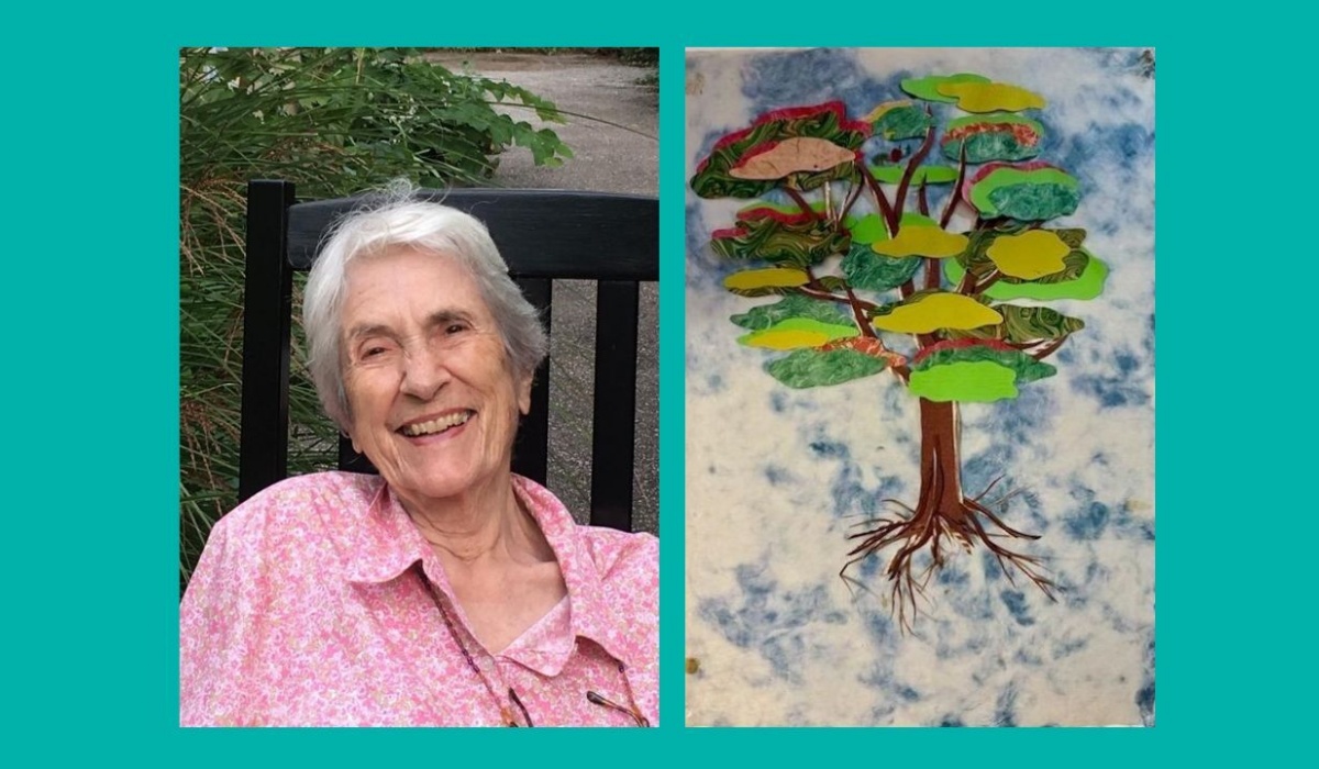 Lore sits on a wooden garden bench smiling at the camera, in a pink shirt and grey-haired. To her right is an image of her collage art work of a tree.